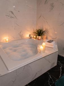 a bathroom with a tub with candles and lit candlesktop at Torraille Waterfall Villas Main Suites in Soufrière +12 photos