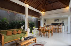 ein Wohnzimmer mit einer grünen Couch und einem Tisch in der Unterkunft Sandi Agung Villa in Seminyak
