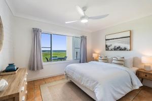 a bedroom with a bed and a large window at Absolute Beachfront Apartment 2B in Lennox Head