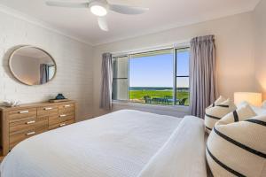 a bedroom with a bed and a large window at Absolute Beachfront Apartment 2B in Lennox Head