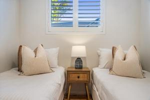 two twin beds in a bedroom with a window at Absolute Beachfront Apartment 2B in Lennox Head