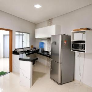 a kitchen with a stainless steel refrigerator and microwave at Anápolis city in Anápolis