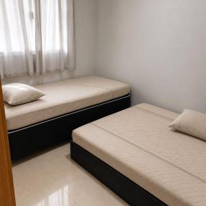 two twin beds in a bedroom with a window at Anápolis city in Anápolis