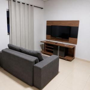 a living room with a couch and a flat screen tv at Anápolis city in Anápolis