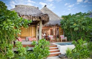 a resort with a pool and a thatch roof at Likuliku Lagoon Resort - Adults Only in Malolo