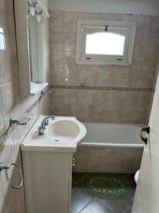 a white bathroom with a sink and a bath tub at LenPui I in Ostende