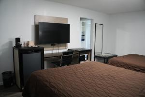 a hotel room with two beds and a flat screen tv at Relax Inn in Webster