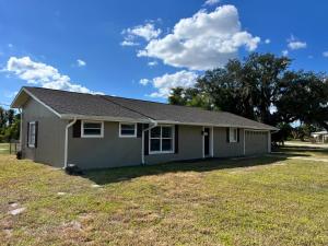a small house in a yard with a grass field at my place to be in Port Charlotte