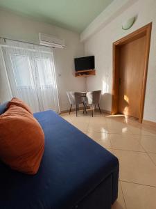 a room with a bed and a table and a television at Apartmani Znaor in Baška Voda