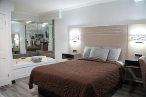 a hotel room with a bed and a bath tub at Relax Inn in Webster