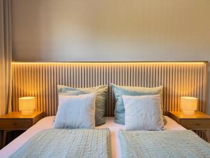 a bedroom with two beds with pillows and two lamps at Strandloft Pippa in Borkum