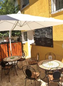 twee tafels en stoelen onder een parasol op een patio bij Tribu Malen Apartamentos in Temuco