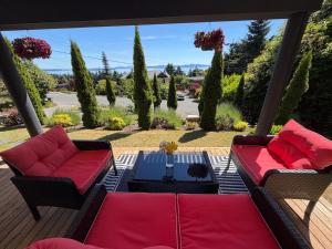 a patio with two couches and a table at Cozy Ocean View Retreat in Victoria
