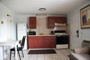 a kitchen with red cabinets and a sink and a table at Relax Inn in Webster