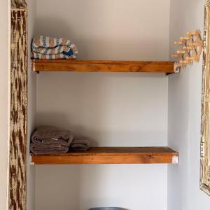 a wooden shelf on a wall with towels on it at Kcasa13 in Corumbau