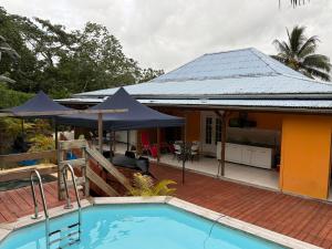 a house with a swimming pool in front of a house at Le Pavillon Ananas in Gros-Morne