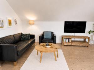 a living room with a couch and a table at Modernes Ferienhaus mit großer Küche, Terrasse & Garten in Bad Camberg