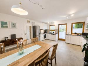 a kitchen and dining room with a large wooden table at Modernes Ferienhaus mit großer Küche, Terrasse & Garten in Bad Camberg