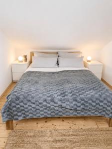 a bed with a blue blanket and two night stands at Modernes Ferienhaus mit großer Küche, Terrasse & Garten in Bad Camberg