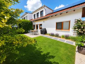 a garden with green grass and a white house at Modernes Ferienhaus mit großer Küche, Terrasse & Garten in Bad Camberg