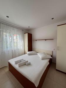 a bedroom with a large bed with two towels on it at Apartmani Znaor in Baška Voda