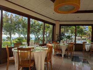 a dining room with tables and chairs and large windows at Villaggio La Pizzuta in Parghelia
