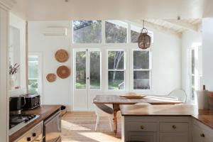 a kitchen with a table and some windows at Circular Bay in Awaroa