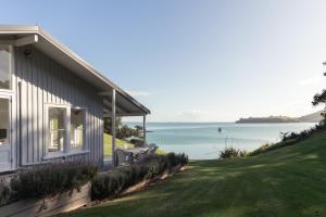a house on a hill with a view of the ocean at Circular Bay in Awaroa