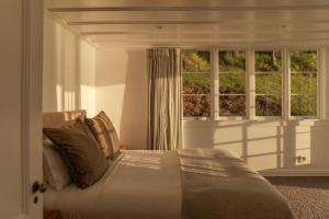 a bedroom with a bed and a window at Circular Bay in Awaroa
