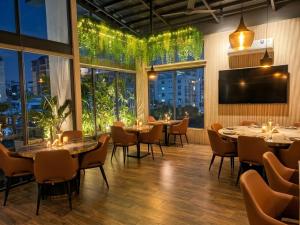a restaurant with tables and chairs and large windows at Imperial Swiss Garden Dhaka in Dhaka