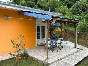a patio with a table and a roof at Sweet Mangot in Gros-Morne