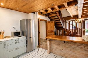 a kitchen with a stainless steel refrigerator and wooden ceilings at Casa Llanes con Jardín, Vistas y Barbacoa – Maruja in La Pereda de Llanes