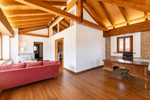 a living room with a red couch and a piano at Casa Llanes con Jardín, Vistas y Barbacoa – Maruja in La Pereda de Llanes