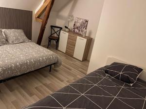 a bedroom with a bed and a dresser at Villa des marots in Troyes