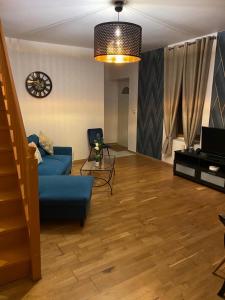 a living room with a blue couch and a television at Villa des marots in Troyes