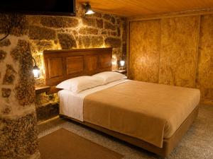 a bedroom with a bed in a stone wall at Casas da Villa- Monsanto in Monsanto