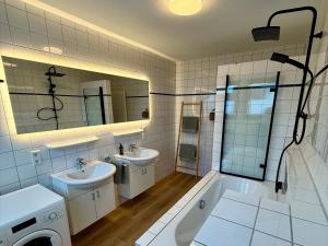 a bathroom with two sinks and a tub and a shower at Strandloft Pippa in Borkum