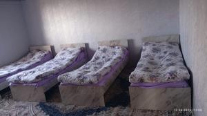 three beds sitting in a corner of a room at Mamyr Guest House in Sary-Mogul +6 photos