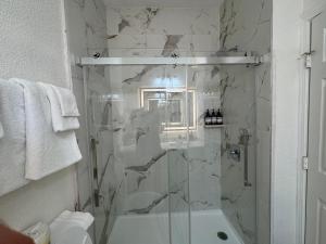 a bathroom with a shower with a glass door at Athens Hotel & Suites in Houston