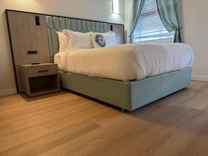 a bedroom with a bed with a large headboard and a window at Athens Hotel & Suites in Houston +12 photos