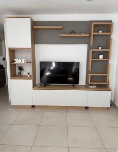 a living room with a tv on a wall at Aura Residence in Comodoro Rivadavia