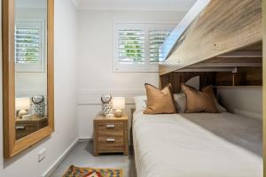 a bedroom with a bed and a mirror at Absolute Beachfront Apartment 3B in Lennox Head