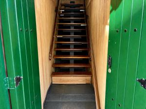 a staircase in a green room with green doors at Chalet de carmelita in Nobsa
