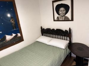 a room with a bed and a picture of a woman at Chalet de carmelita in Nobsa