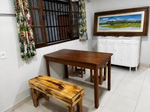 a wooden table and stool in a room with a window at Sossai Hostel in Vitória