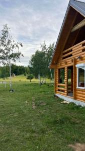 a log cabin in a grassy field with trees at Camp Birch Forest in Pljevlja
