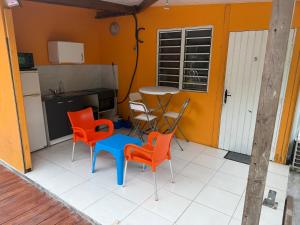 a kitchen with a table and chairs in a room at L'évasion Maracuja in Gros-Morne