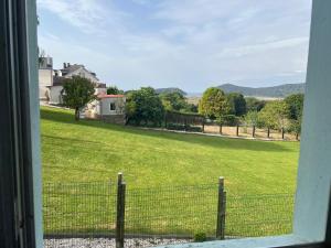 a view from a window of a field with a fence at La Casa Azul en Ortigueira in Santa Marta de Ortigueira