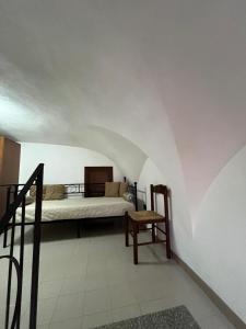 a bedroom with a bed and a chair in a room at Antica Casa Cavaliere in Tramonti