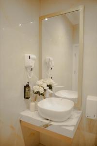 a white bathroom with a sink and a mirror at Kiranovi Premium Stay in Bitola